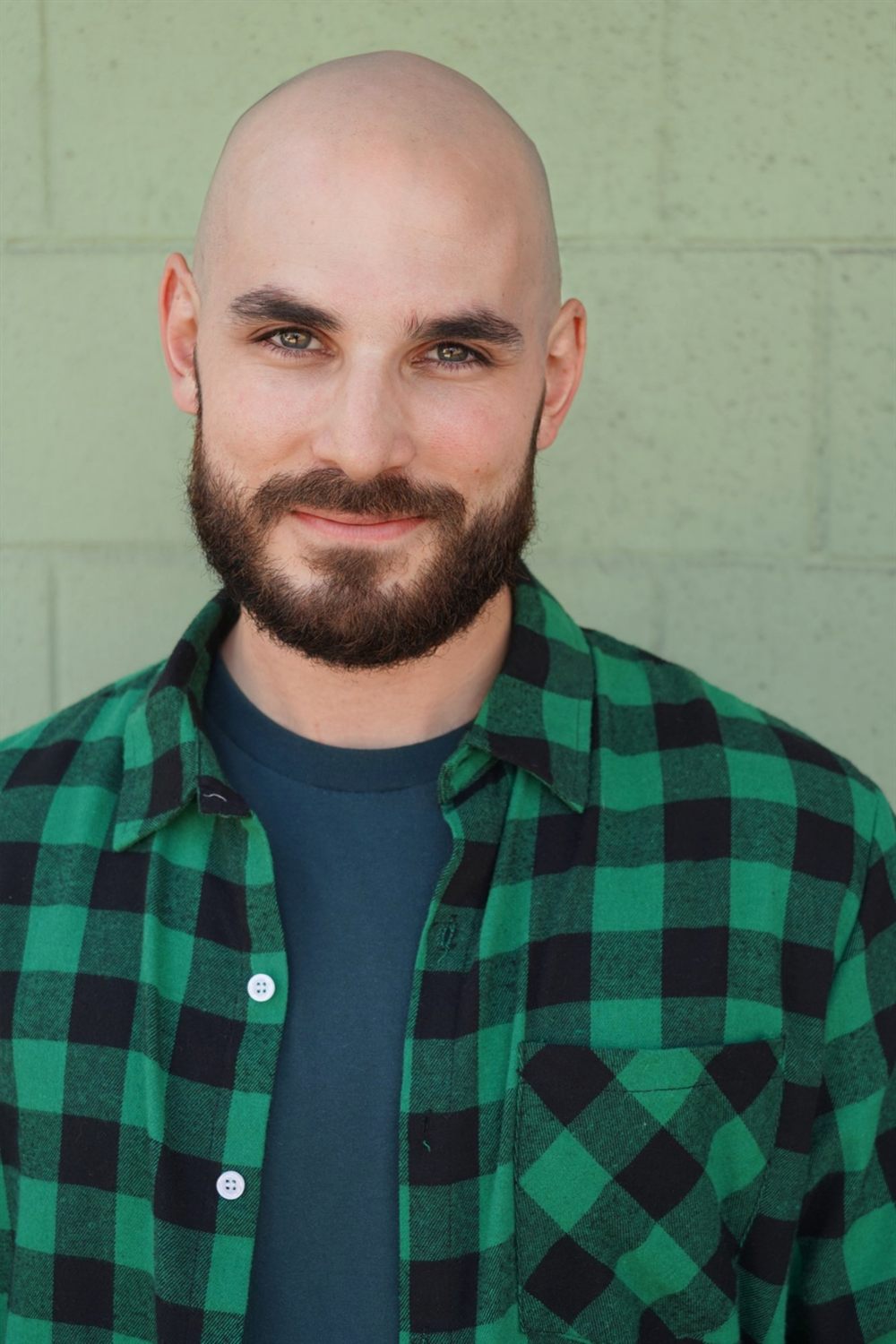 Sirko smiling in a green flannel shirt